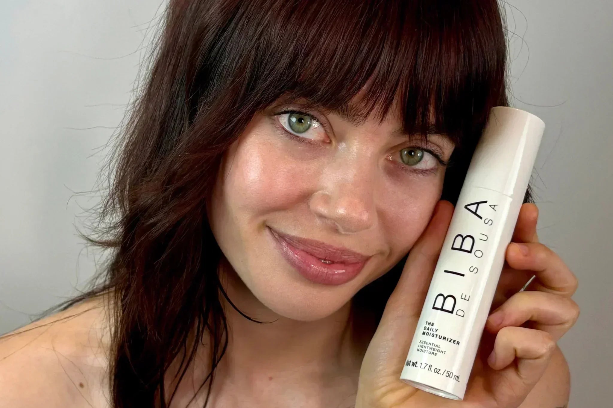 Woman holding Biba de Sousa Los Angeles Daily Moisturizer, highlighting lightweight daily hydration for healthy skin