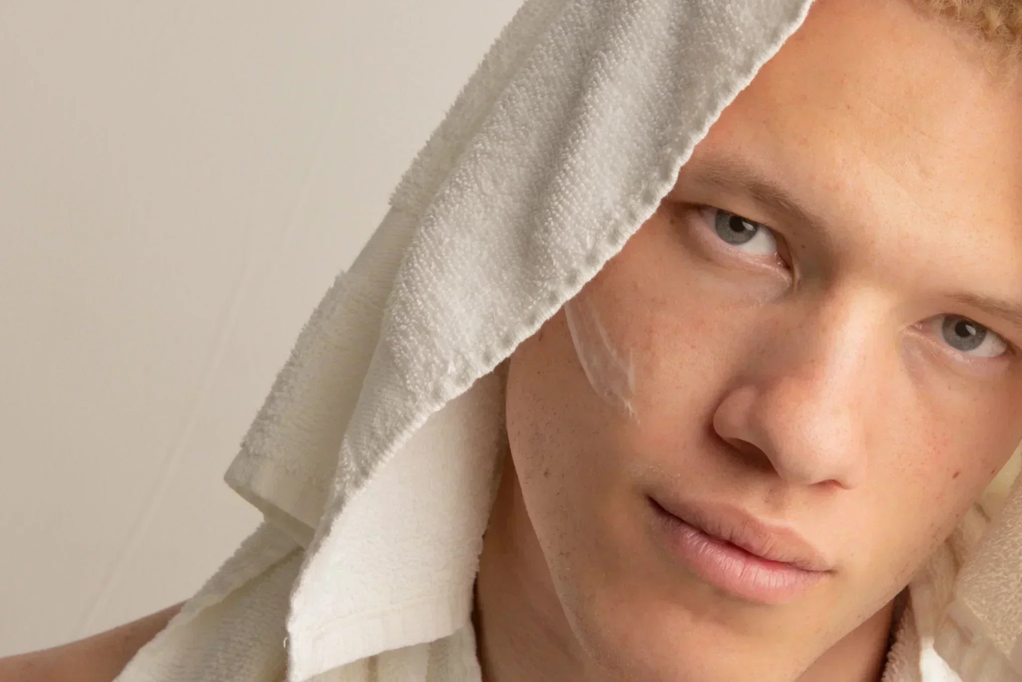 Man with healthy skin wearing a towel after cleansing, representing a simple men’s skincare routine