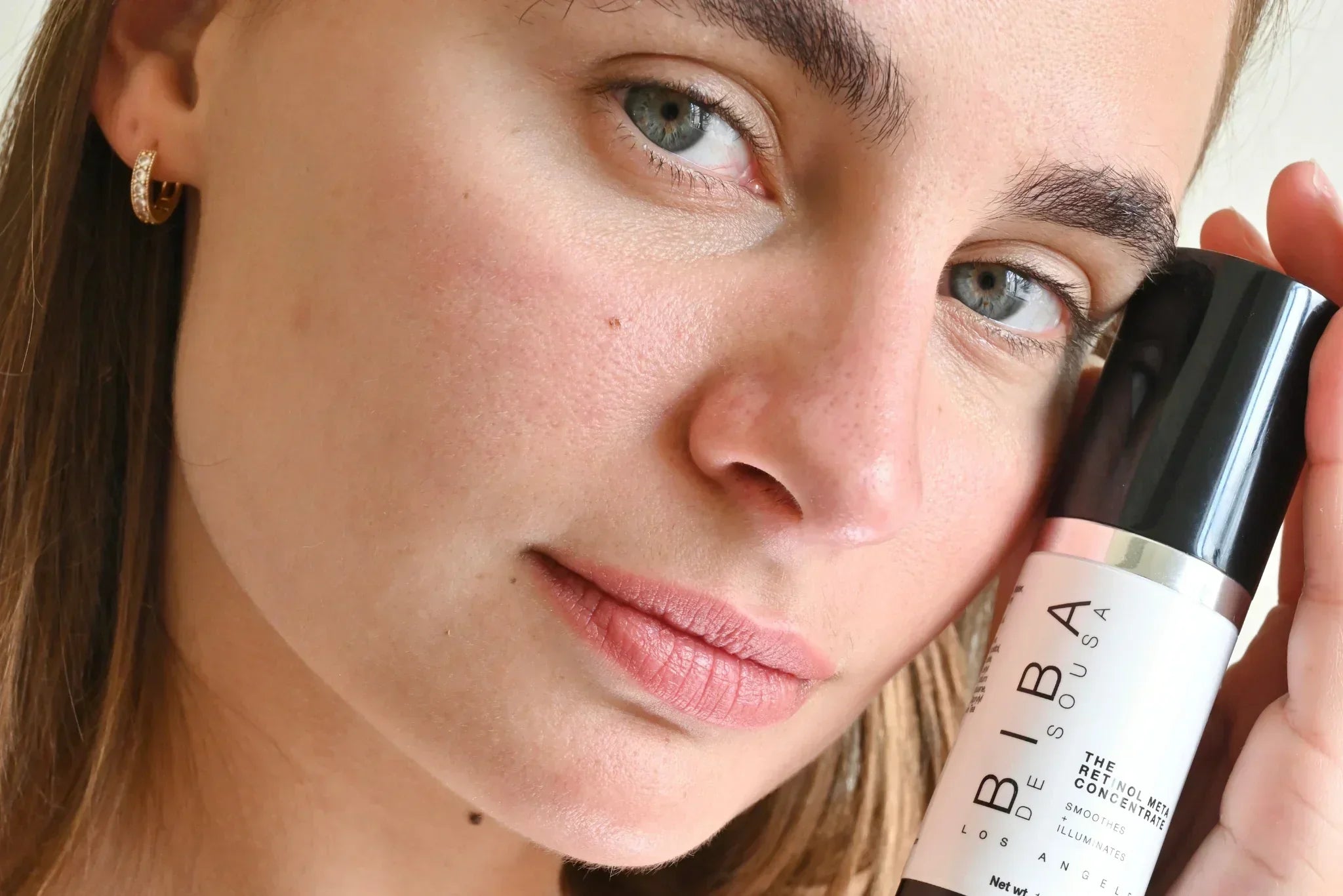 Woman holding Biba de Sousa Retinol Meta Concentrate close to her face, showcasing smooth, radiant skin