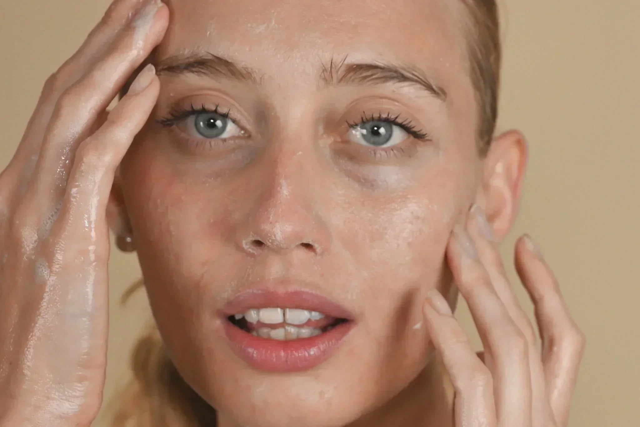 Woman cleansing her face with gentle skincare routine, demonstrating proper barrier-friendly cleansing