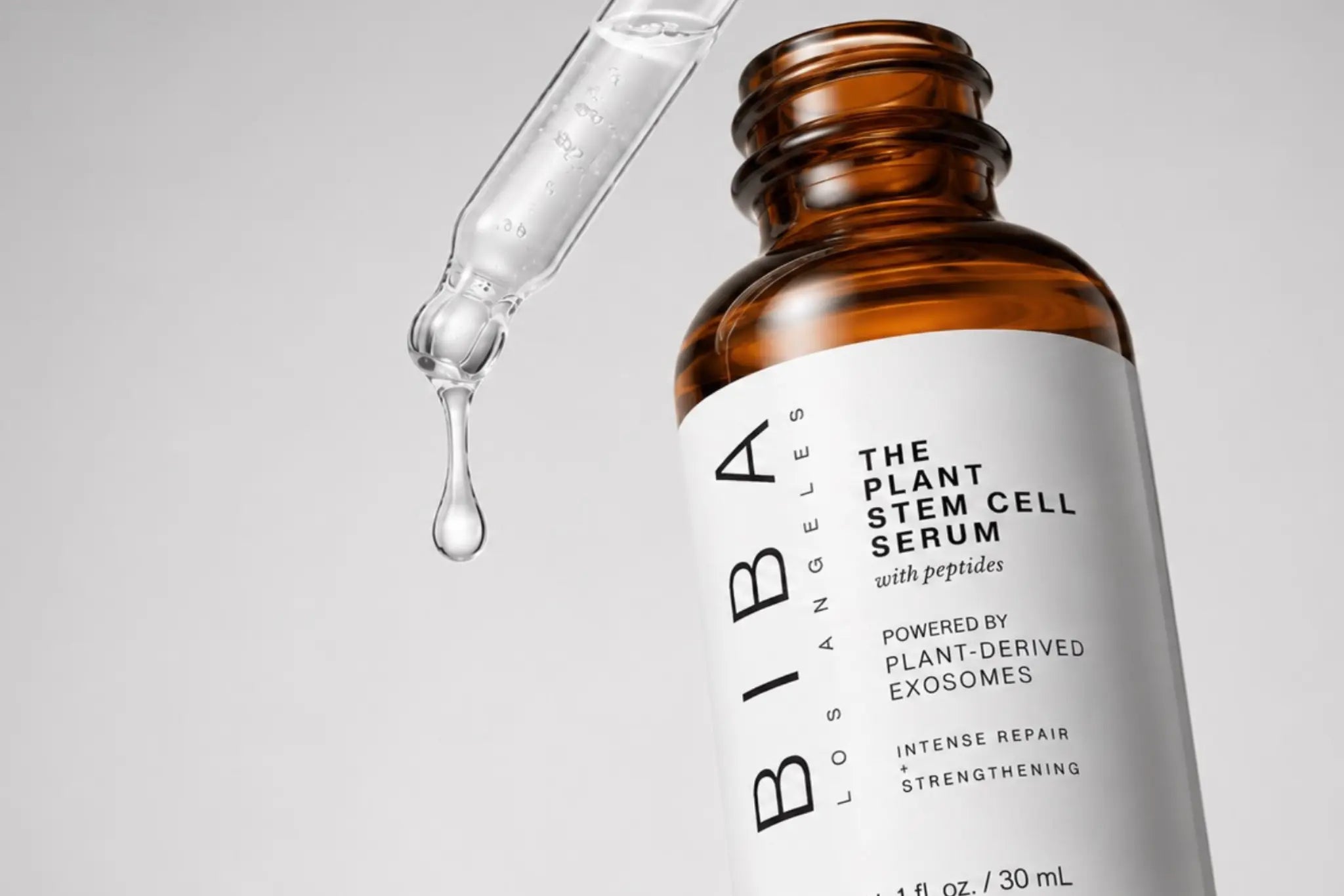 Close-up of Biba Los Angeles Plant Stem Cell Serum with Peptides powered by plant-derived exosomes, featuring an amber glass bottle and serum dropper against a light grey background.