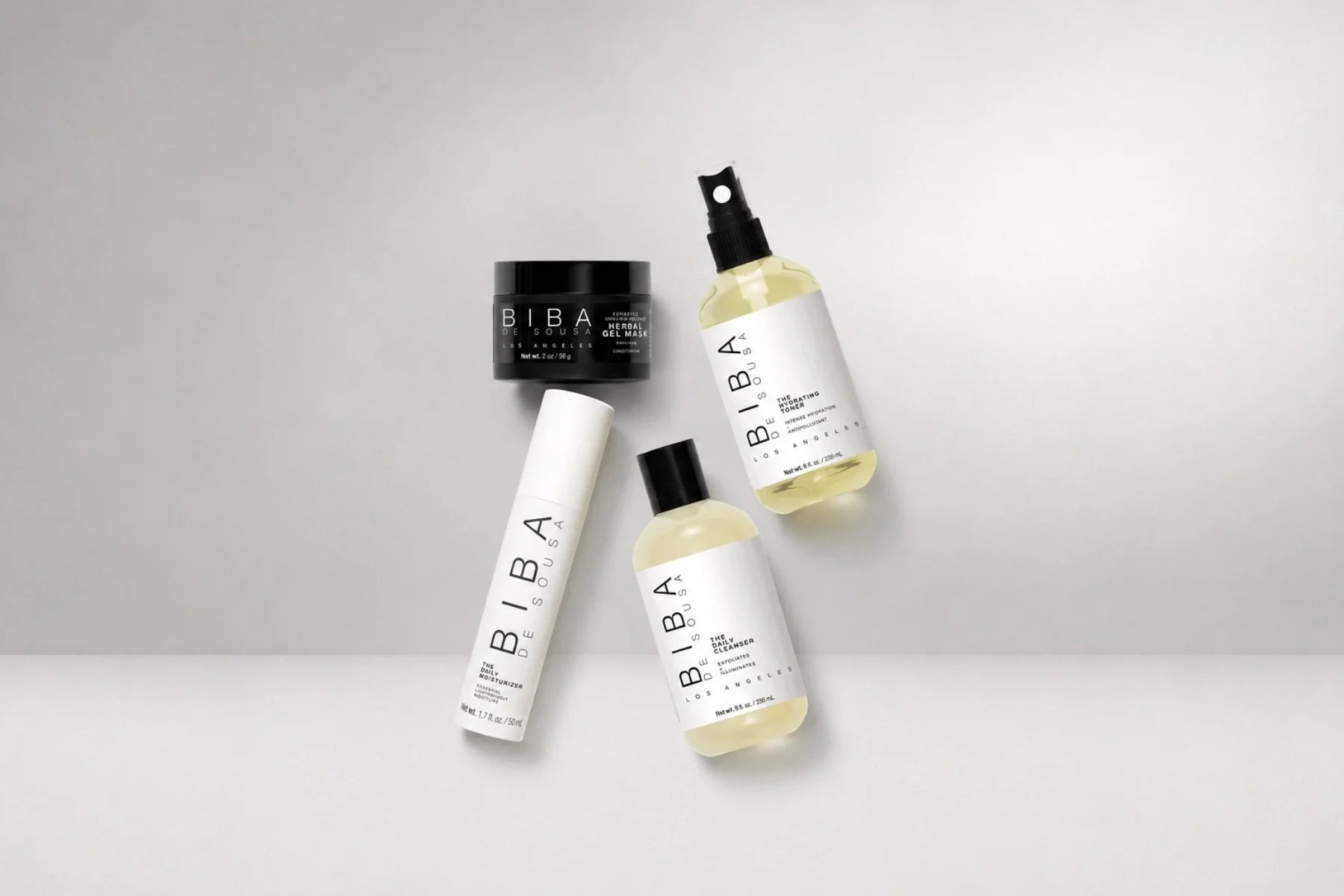BIBA Los Angeles hydrating skincare bundle featuring the Daily Cleanser, Hydrating Toner, Daily Moisturizer, and Herbal Gel Mask arranged in a luxury studio composition on a light gray background.