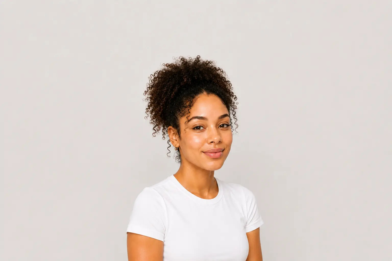 Woman with healthy, hydrated skin wearing a white top against a light gray background with generous negative space, representing barrier support, hydration, and healthy skin.