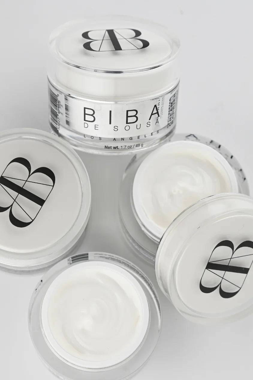 Arrangement of open and closed BIBA Los Angeles Cream Barrier moisturizer jars showing the cream texture and packaging on a light background.