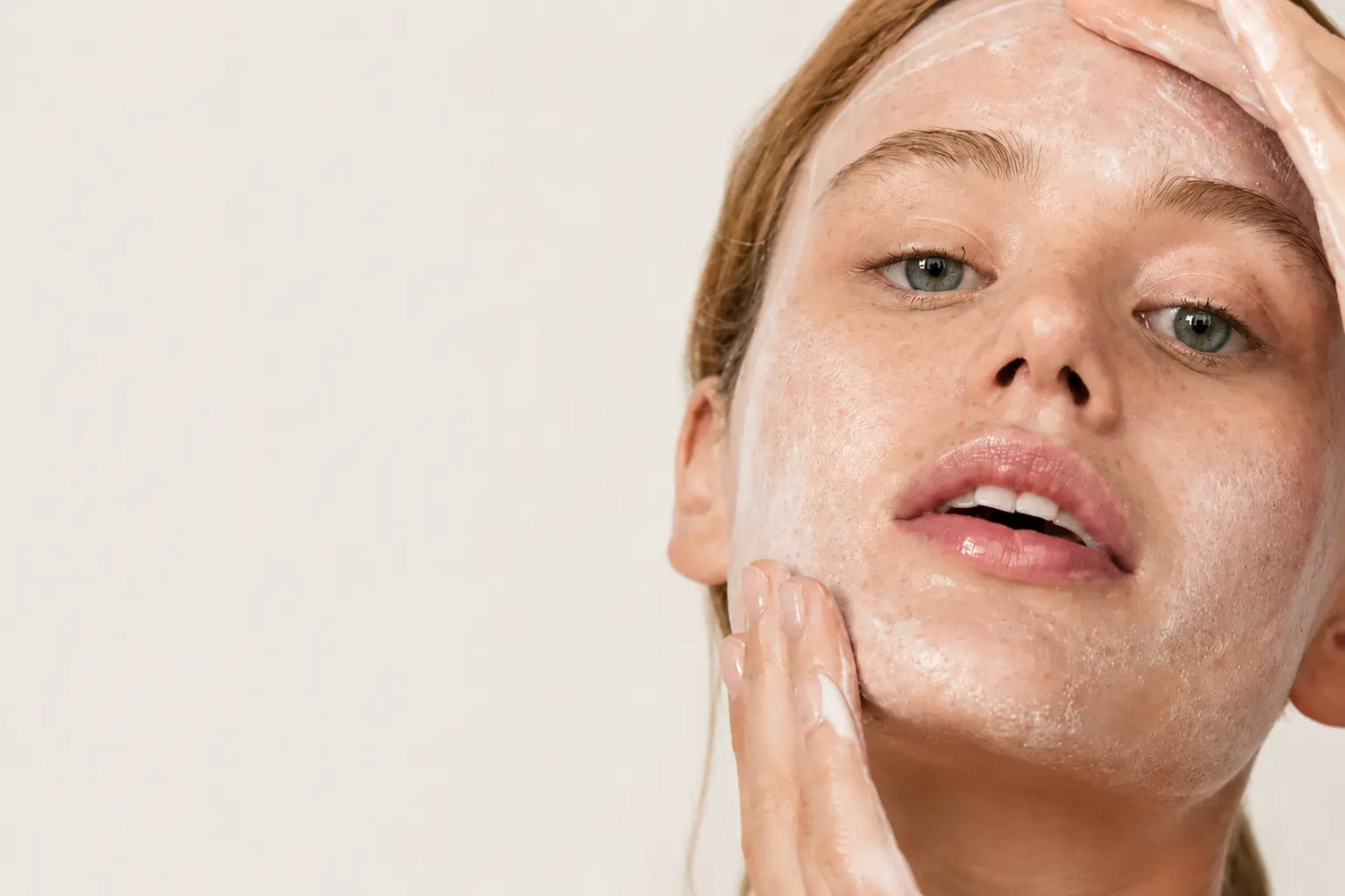 Woman washing her face with a gentle cleanser demonstrating proper facial cleansing techniques for healthy skin