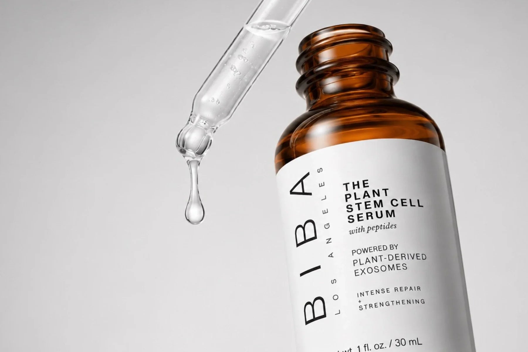 Close-up of BIBA Los Angeles Plant Stem Cell Serum with Peptides powered by plant-derived exosomes, featuring a clear serum dropper against a light gray studio background.