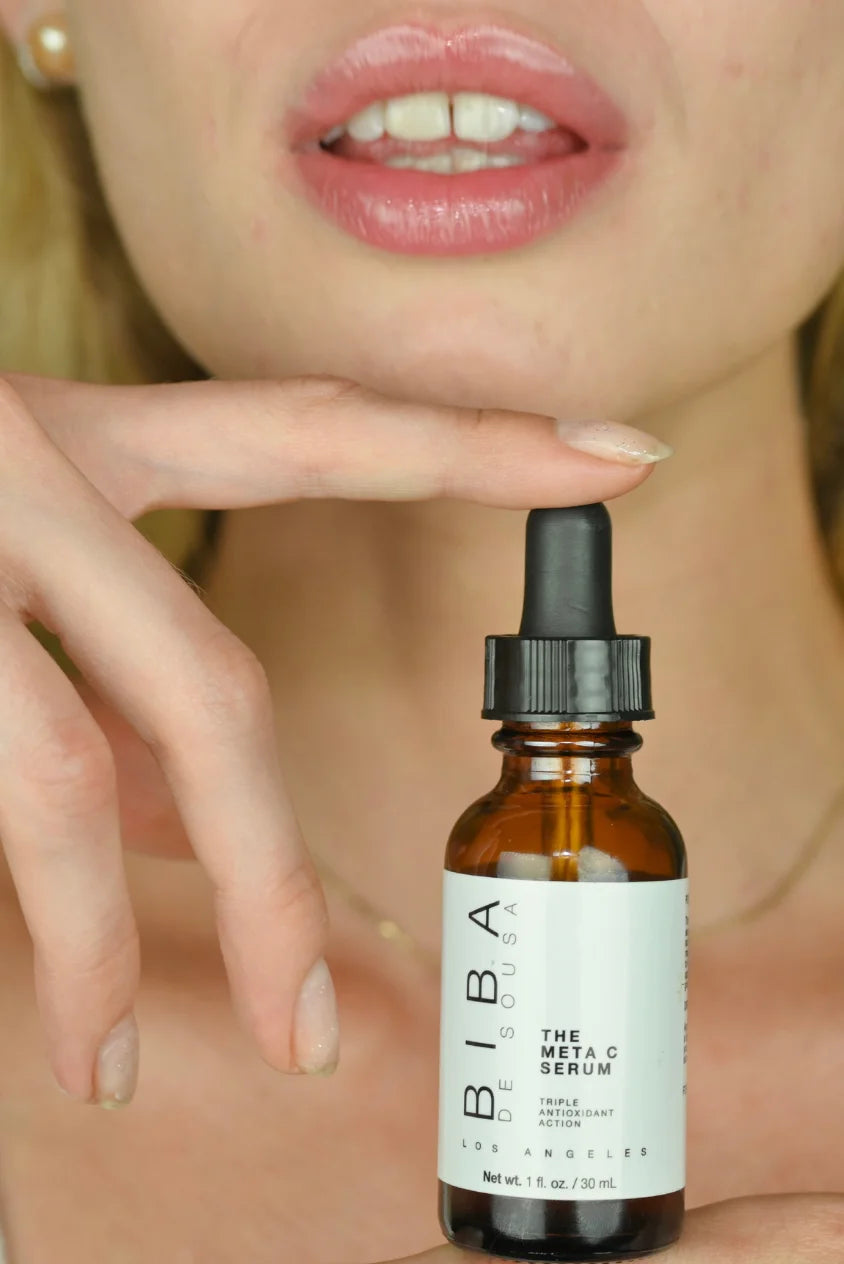 Amber glass dropper bottle of BIBA Los Angeles Meta C Serum displayed in a close-up skincare image.
