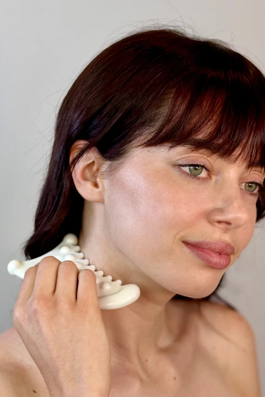 Woman using Biba de Sousa Meta Facial Fascia Tool on neck for lymphatic drainage and fascia massage