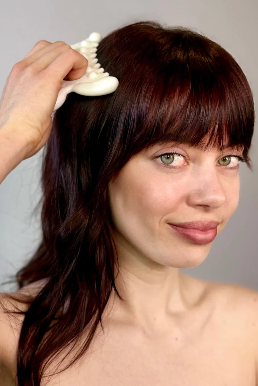 Woman using Biba de Sousa Meta Facial Fascia Tool on scalp for fascia release and scalp stimulation
