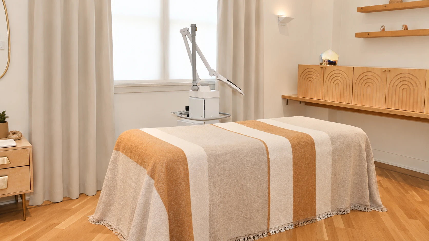 Minimalist BIBA Los Angeles facial treatment room with a spa treatment bed, soft neutral decor, and floor-length blanket cover.
