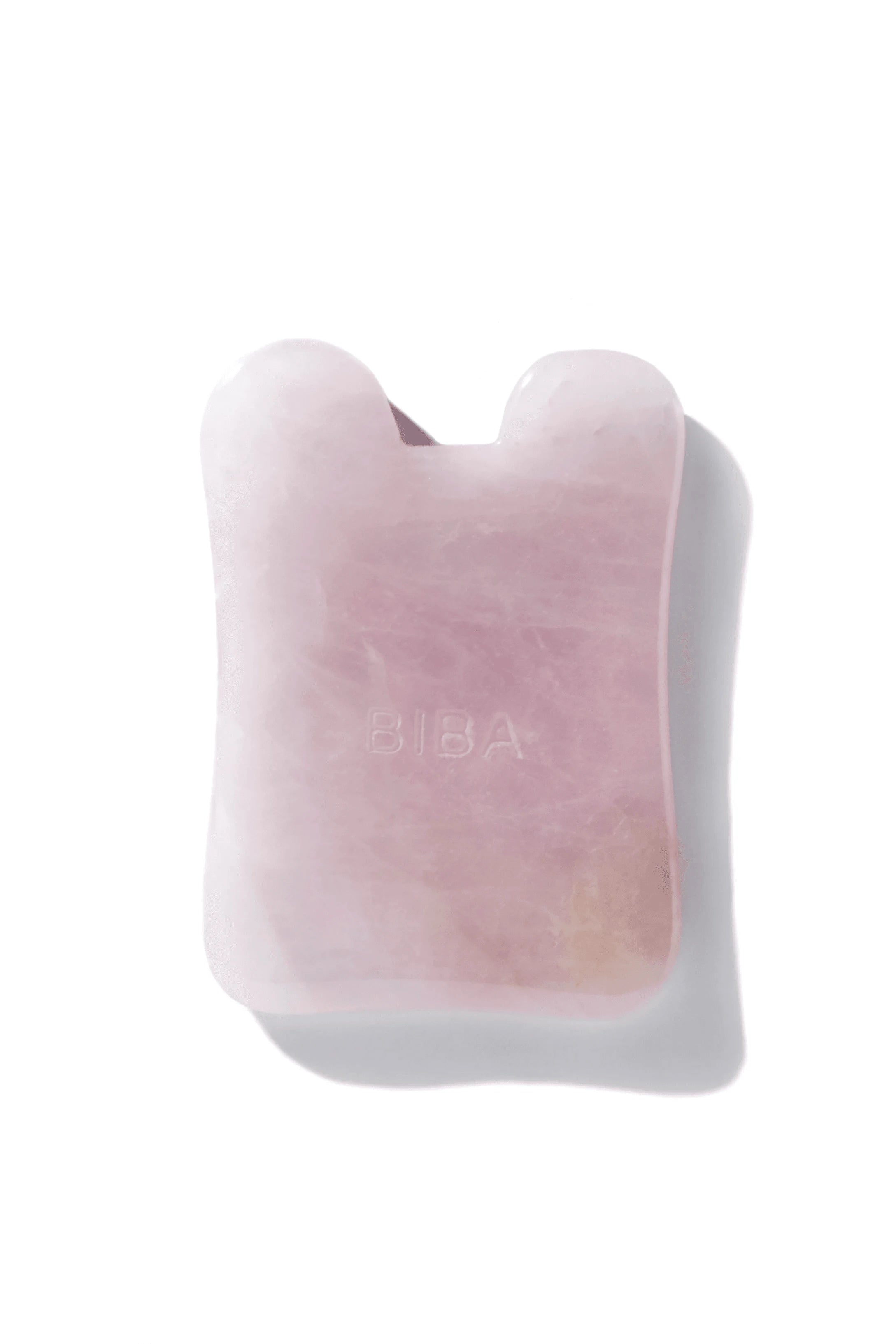 Biba Los Angeles pink gua sha facial board massage tool made from polished stone for facial massage and lymphatic drainage.